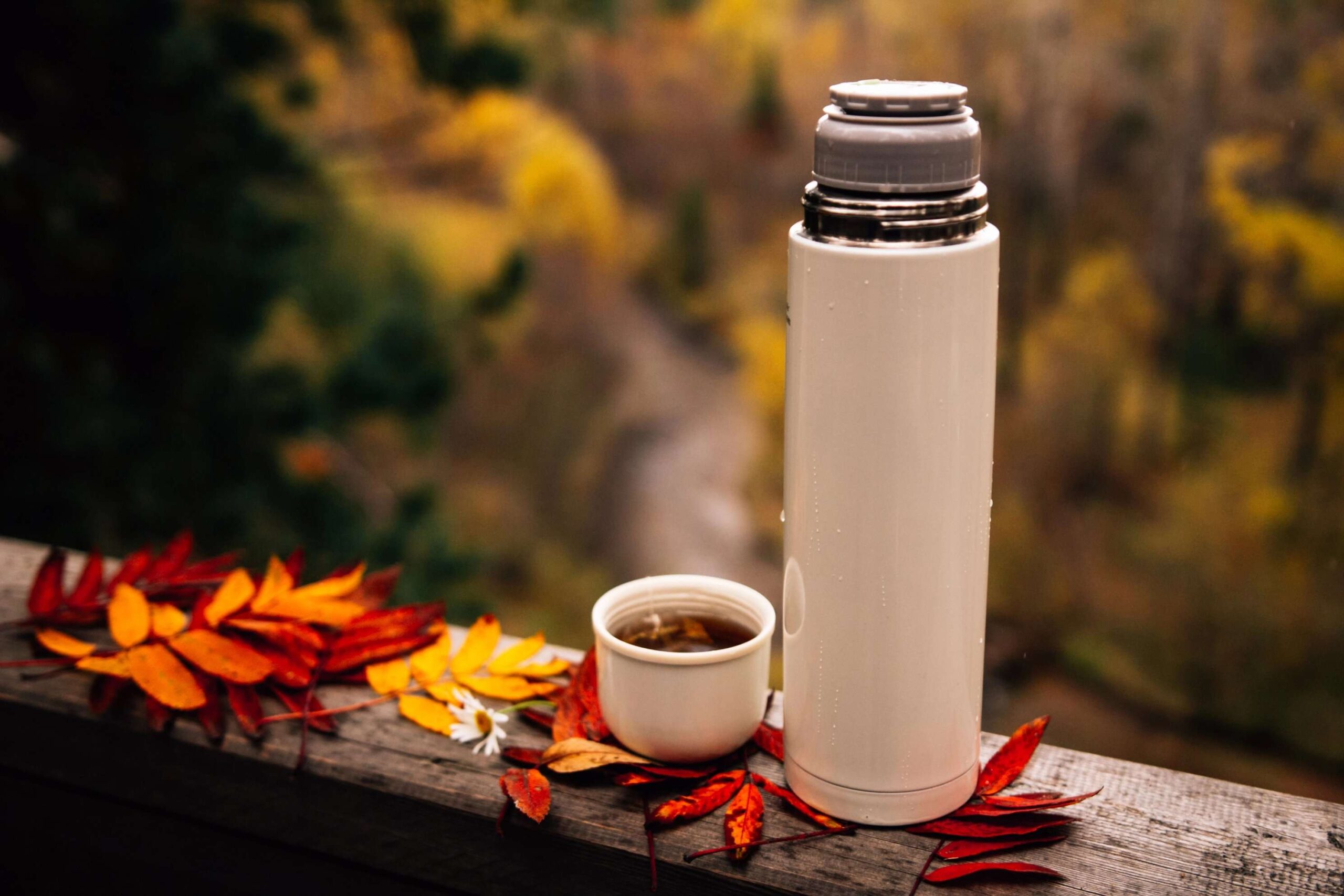 A warm fall drink from a thermos set outside on a deck